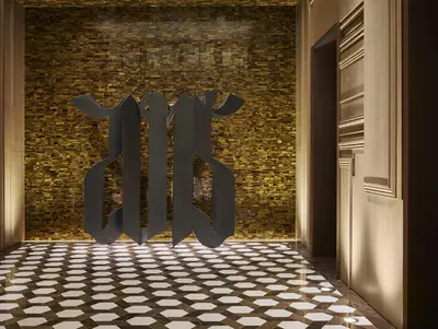a door to a brick wall with a checkered floor at Rosewood Bangkok in Bangkok