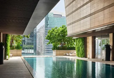 a swimming pool in the middle of a building at Rosewood Bangkok in Bangkok