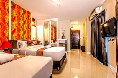 a hotel room with two beds and a flat screen tv at The Aim Sathorn Hotel in Bangkok