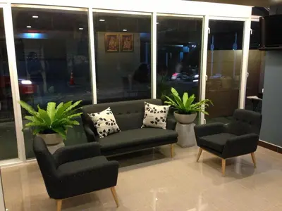 a living room with a couch and two chairs at The Aim Sathorn Hotel in Bangkok