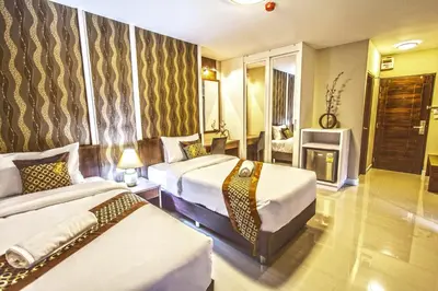 a hotel room with two beds and a television at The Aim Sathorn Hotel in Bangkok