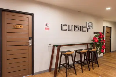 a room with a table and four stools at Cubic Bed Pratunam in Bangkok