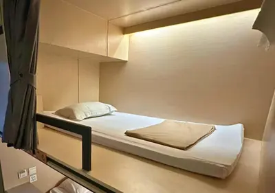 a small bedroom with a bed in a room at Cubic Bed Pratunam in Bangkok