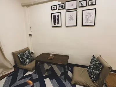 a living room with a table and two chairs at House 116 in Bangkok