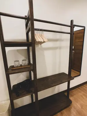 a wooden book shelf with two glasses on it at House 116 in Bangkok