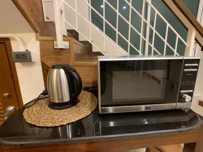 a microwave oven sitting on a counter with a hat at House 116 in Bangkok