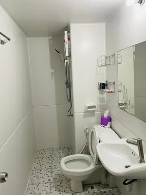 a white bathroom with a toilet and a sink at Dailyroom by Anna C1-C9 in Nonthaburi