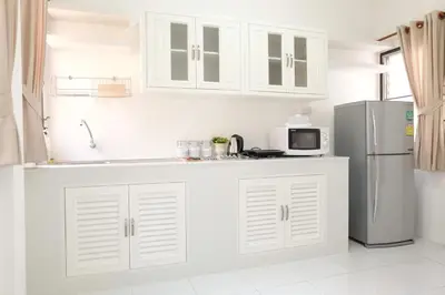 a kitchen with white cabinets and a refrigerator at Chatuchak Art & Nature House ( 3-6 pers.) in Bangkok