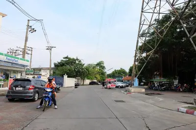 a person riding a motorcycle on a street at Chatuchak Art & Nature House ( 3-6 pers.) in Bangkok