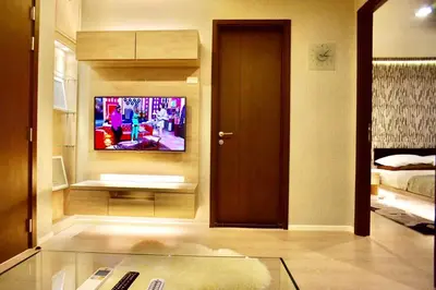 a living room with a tv on a wall at Luxury Apartment near Downtown (Pick-up Service) in Bangkok