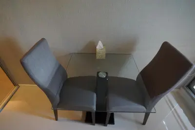 a glass table with two chairs and a clock on it at Luxury Apartment near Downtown (Pick-up Service) in Bangkok