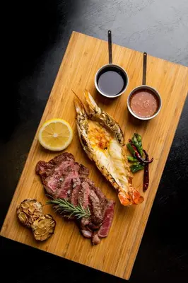 a cutting board with fish and other foods on it at Sala Rattanakosin Bangkok in Bangkok