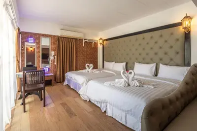 two beds in a hotel room with two swans on them at Infinite Hotel in Bangkok