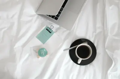 a cup of coffee and a laptop on a bed at Chocolate box mint in Bangkok