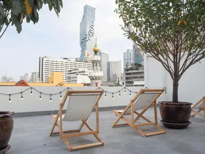 two chairs sitting on a rooftop with a tree at Chocolate box mint in Bangkok