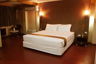 a large white bed in a hotel room at Visiting Card Hotel & Resort in Bangkok
