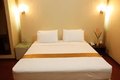 a bedroom with a large white bed with two pillows at Visiting Card Hotel & Resort in Bangkok