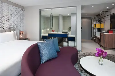 a bedroom with a bed and a table and a couch at Avani Sukhumvit Bangkok Hotel in Bangkok