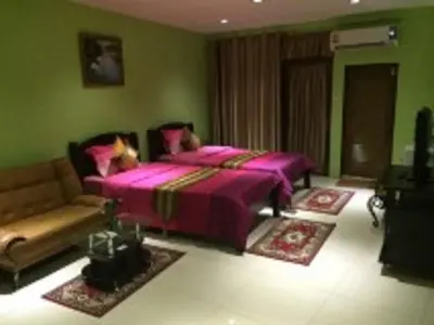 a bedroom with a pink bed and a couch at Penang Palace in Bangkok