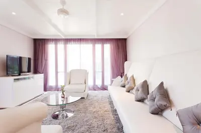 a living room with a white couch and a glass table at Hua Chang Heritage Hotel in Bangkok
