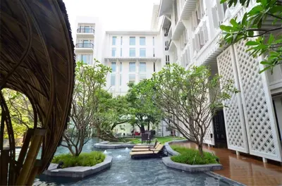 a courtyard in a building with trees and water at Hua Chang Heritage Hotel in Bangkok