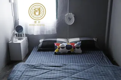 a small bedroom with a bed with two pillows at Hong hostel in Bangkok