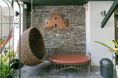 a chair on a balcony with a brick wall at Castle Black Bangkok in Bangkok