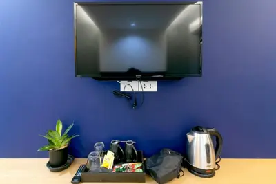 a flat screen tv hanging on a blue wall at Castle Black Bangkok in Bangkok