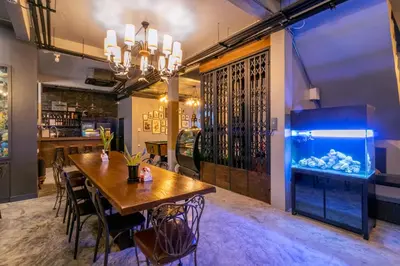 a dining room with a table and an aquarium at Castle Black Bangkok in Bangkok