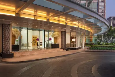 a large building with glass windows in a city at Dusit Suites Hotel Ratchadamri, Bangkok in Bangkok