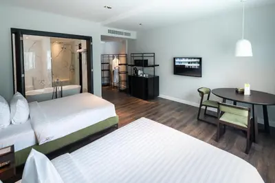 a hotel room with two beds and a table at S Ram Leisure Hotel in Bangkok
