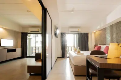a hotel room with a bed and a desk at The Home Hotel SHA in Bangkok