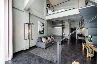 a living room with a couch and a table at Palette The Ex Capital Hotel Bangkok in Bangkok