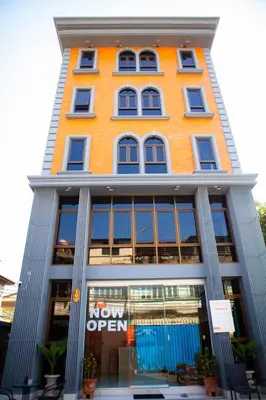 a orange building with a now open sign on it at Rich8 Hostel in Bangkok