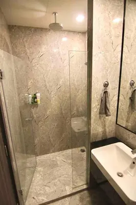 a bathroom with a glass shower and a sink at Luxurious & Romantic in the Heart of BKK#H MRT/BTS! in Bangkok