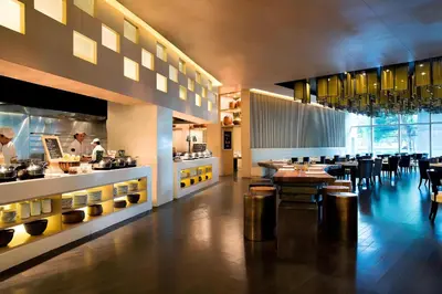 a restaurant with a chef preparing food in a kitchen at Marriott Executive Apartments Bangkok, Sukhumvit Thonglor in Bangkok