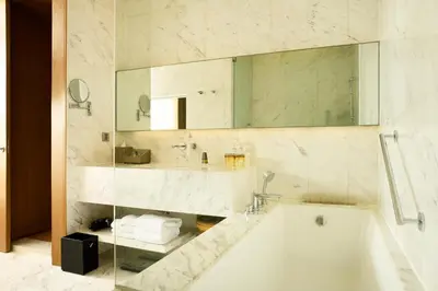 a bathroom with a tub and a sink and a mirror at Marriott Executive Apartments Bangkok, Sukhumvit Thonglor in Bangkok