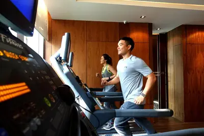 a man and a woman walking on a treadmill in a gym at Marriott Executive Apartments Bangkok, Sukhumvit Thonglor in Bangkok
