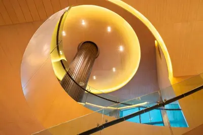 a large spiral staircase in a building with a yellow circle at Marriott Executive Apartments Bangkok, Sukhumvit Thonglor in Bangkok