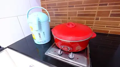 a red pot sitting on top of a stove at Ploenchit Mansion in Bangkok