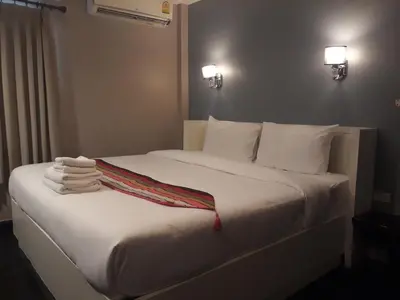 a bedroom with a white bed with towels on it at V30 Sukhumvit in Bangkok