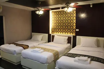 a room with four beds and a window at V30 Sukhumvit in Bangkok