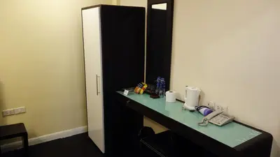 a room with a desk with a phone and a mirror at V30 Sukhumvit in Bangkok