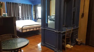 a blue room with a bed and a table and chair at bangkok bed place in Bangkok