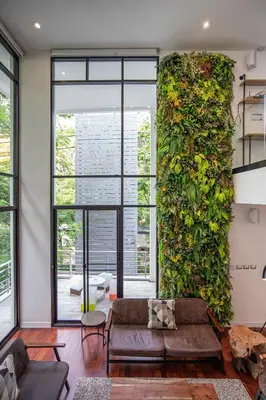 a living room with a large green wall at Benviar Tonson Residence in Bangkok