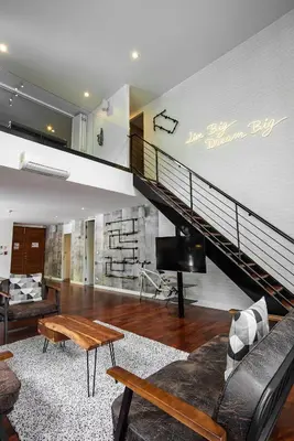 a living room with a staircase and a couch at Benviar Tonson Residence in Bangkok
