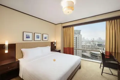 a hotel room with a bed and a large window at Conrad Bangkok Residences in Bangkok