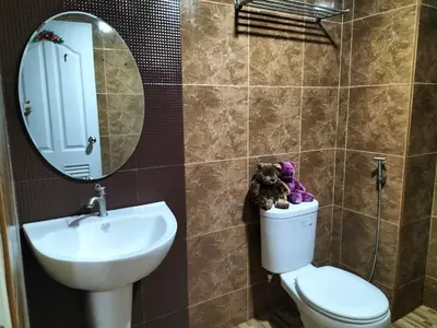 a bathroom with a sink and a toilet and a mirror at พีเพลส in Bangkok