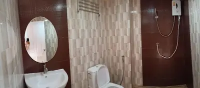 a bathroom with a toilet and a sink and a mirror at พีเพลส in Bangkok