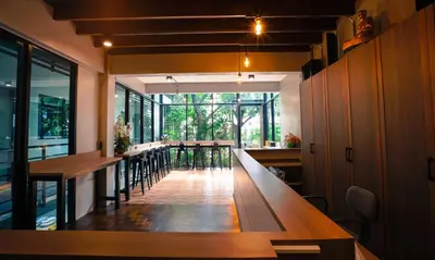 a restaurant with tables and chairs and a large window at Bed garden 26 in Bangkok